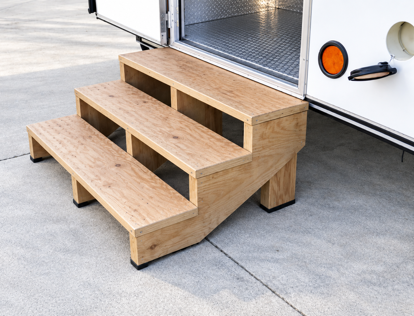 Wood entry stairs installed beside a commercial mobile trailer
